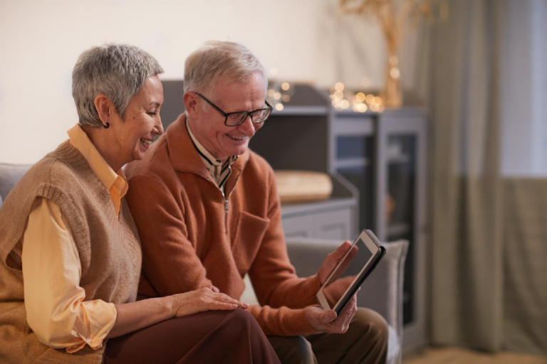 Photo d'un couple de personne âgée regardant une tablette